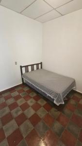 Ce lit se trouve dans un dortoir doté de carrelage. dans l'établissement La Casa de Don Carlos, à Usulután