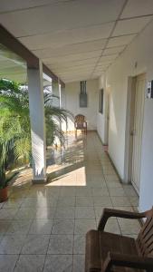 Cette chambre dispose d'une terrasse couverte avec des chaises et des palmiers. dans l'établissement La Casa de Don Carlos, à Usulután