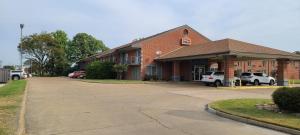 ein Backsteingebäude mit einem Parkplatz davor in der Unterkunft Fairview Inn & Suite in Jonesboro