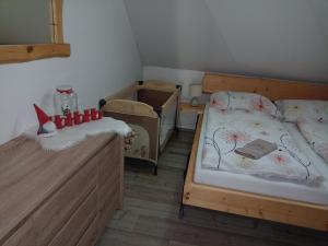1 Schlafzimmer mit 2 Einzelbetten und einem Kinderbett in der Unterkunft Zrub Jánošík in Valča
