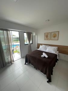 Un dormitorio con una cama con una toalla. en Makia Beach Experience - Flat 16A - TÉRREO - SOFT OPENING, en Porto de Galinhas