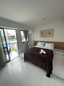 Un dormitorio con una cama con una toalla. en Makia Beach Experience - Flat 16A - TÉRREO - SOFT OPENING, en Porto de Galinhas