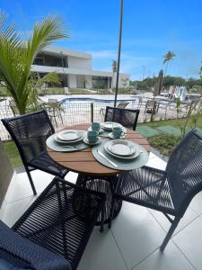 a wooden table and chairs on a patio at Makia Beach Experience - Flat 16A - TÉRREO - SOFT OPENING in Porto De Galinhas