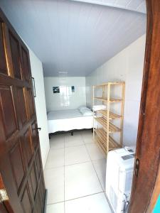 a small room with a small bed and a shelf at Suítes Brisa Tropical in Cabo Frio
