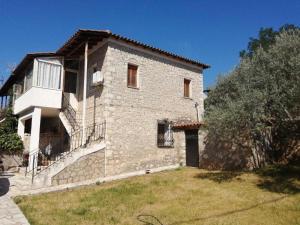 a large stone house with a yard in front of it at Parnassos cottage 