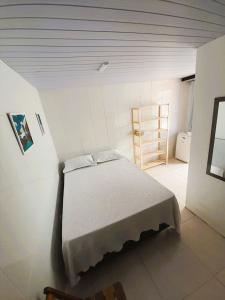 1 dormitorio con 1 cama en una habitación blanca en Suítes Brisa Tropical en Cabo Frío