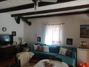 a living room with a blue couch and a window at Parnassos cottage in Mavronérion