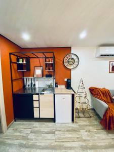 una cucina con pareti arancioni e bancone in una stanza di Gîte chez EsTé a Mittelwihr
