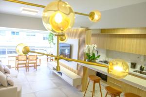 a living room with a large gold light fixture at Apartamento Vista Mar 2 quartos em Condomínio Clube a 100 metros da Praia do Campeche, Florianópolis in Florianópolis