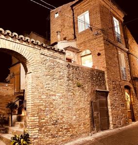 a large brick building with an archway on a street at Al Civico 2 in Atri