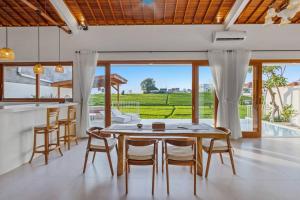 uma cozinha e sala de jantar com mesa e cadeiras em Villa Swantika: Infinity Pool Aussicht Canggu em Canggu