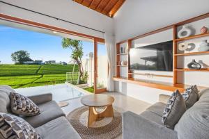 uma sala de estar com um sofá e uma mesa em Villa Swantika: Infinity Pool Aussicht Canggu em Canggu