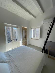 a white bedroom with a large bed and two windows at Al Civico 2 in Atri
