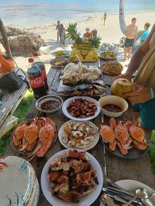 a table with seafood and other food on the beach at ITAYTAY INN in San Vicente