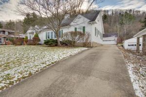 a white house with snow on the ground at Charming and Spacious Olean Home with 2 Fireplaces in Olean