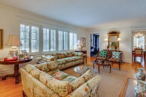 a living room with couches and tables and windows at Charming and Spacious Olean Home with 2 Fireplaces in Olean