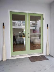 a green door on a house with two wooden bats at Venice Canals & Beach Guest Studio in Los Angeles