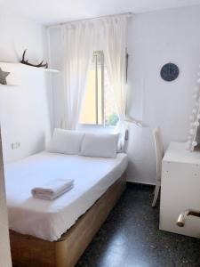 a small bedroom with a bed with a window at Acogedora y soleada habitación cerca de la playa y universidades in Valencia