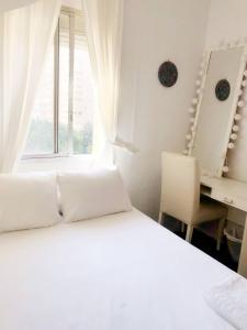 a bedroom with a bed and a desk and a window at Acogedora y soleada habitación cerca de la playa y universidades in Valencia