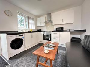 a kitchen with a washer and a table in it at Compact Studio for City Explorers & Adventurers! in Birmingham