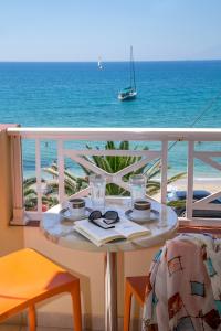 a table on a balcony with a view of the ocean at Studios Akrogiali in Limenaria