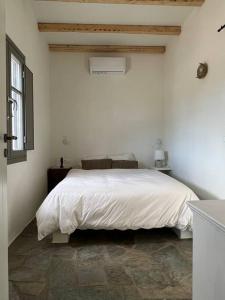 1 dormitorio con cama blanca y ventana en Fyroa en Naxos