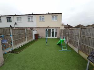 a backyard with a swing set and a playground at Elegant 3-Bedroom Home, sleeps up to 5 guest. in South Ockendon