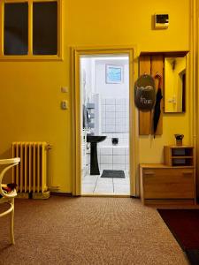 a yellow room with a door leading to a bathroom at AradVest Studio in Arad