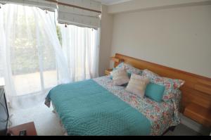 een slaapkamer met een bed met kussens erop bij Dpto duplex 2 dormitorios 2 baños en Laguna Vista ,Algarrobo in Algarrobo