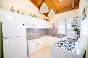 a white kitchen with a stove and a white refrigerator at Golf Villa en Casa de Campo in Cajuiles
