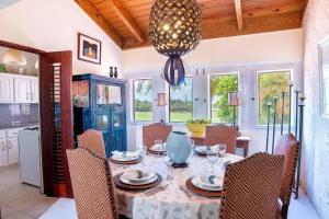 a dining room with a table with chairs and a chandelier at Golf Villa en Casa de Campo in Cajuiles