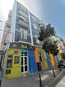 un edificio colorido al lado de una calle en Club Náutico Tomas Miller, en Las Palmas de Gran Canaria