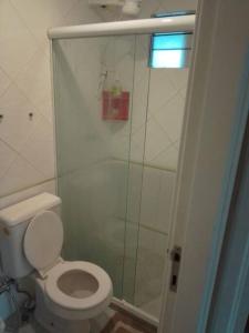 a bathroom with a toilet and a glass shower at Apt Lindíssimo na Pituba in Salvador