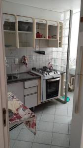 a small kitchen with a stove and a sink at Apt Lindíssimo na Pituba in Salvador