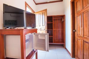 a living room with a tv and a desk with a tvictericter at Hotel Los Corales in West End