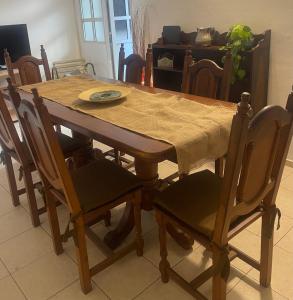 uma mesa de jantar em madeira com cadeiras e uma toalha de mesa em Casa Céntrica totalmente equipada !!! em Santiago del Estero