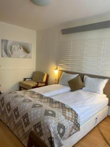 um quarto com uma cama grande e uma cadeira em HQ apartments Villa Park em Borovets