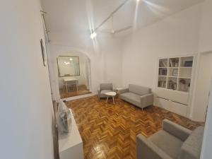uma sala de estar com um sofá, cadeiras e um espelho em Departamento Alto Palermo em Buenos Aires