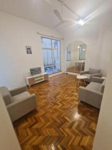 un soggiorno con 2 divani e un pavimento in legno di Departamento Alto Palermo a Buenos Aires