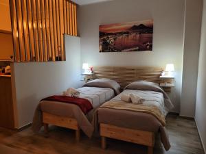 2 camas individuales en una habitación con una foto en la pared en B&B la casa di Vale, en Marigliano