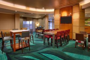a restaurant with tables and chairs and a flat screen tv at SpringHill Suites by Marriott Cedar City in Cedar City
