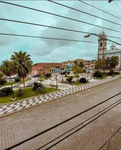 an empty street with a town with a clock tower at Pousada Solar Colonial in Iguape