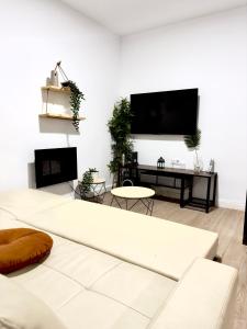 a living room with a white couch and a flat screen tv at Puerto Amazonas apartamento con jacuzzi privado in El Puerto de Santa María