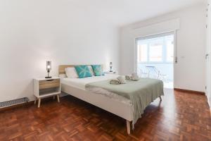 Habitación blanca con cama y ventana en Cascais Beach Flower Apartment en Estoril