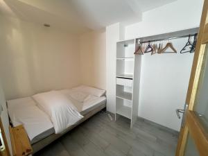 Dormitorio pequeño con cama y armario en Cabana & Les Débuts du Ski en Les Avanchers