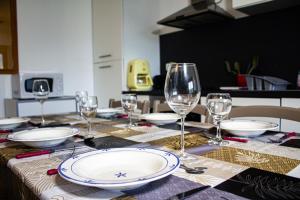 Una mesa con platos y copas de vino encima. en Cabana & Les Débuts du Ski, en Les Avanchers