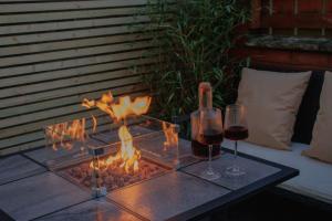 a table with two glasses of wine and a fireplace at Paupies Place Seaside Stay in Cullercoats