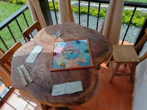 - une table en bois avec une carte sur le balcon dans l'établissement Chalet MOKA la Riviera, à Calima