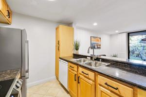 a kitchen with a sink and a refrigerator at Brooks Beach Vacations Cottage G5 Oceanside in Oceanside