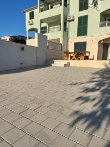 a large building with a brick patio in front of it at Apartments Melissa in Sumartin